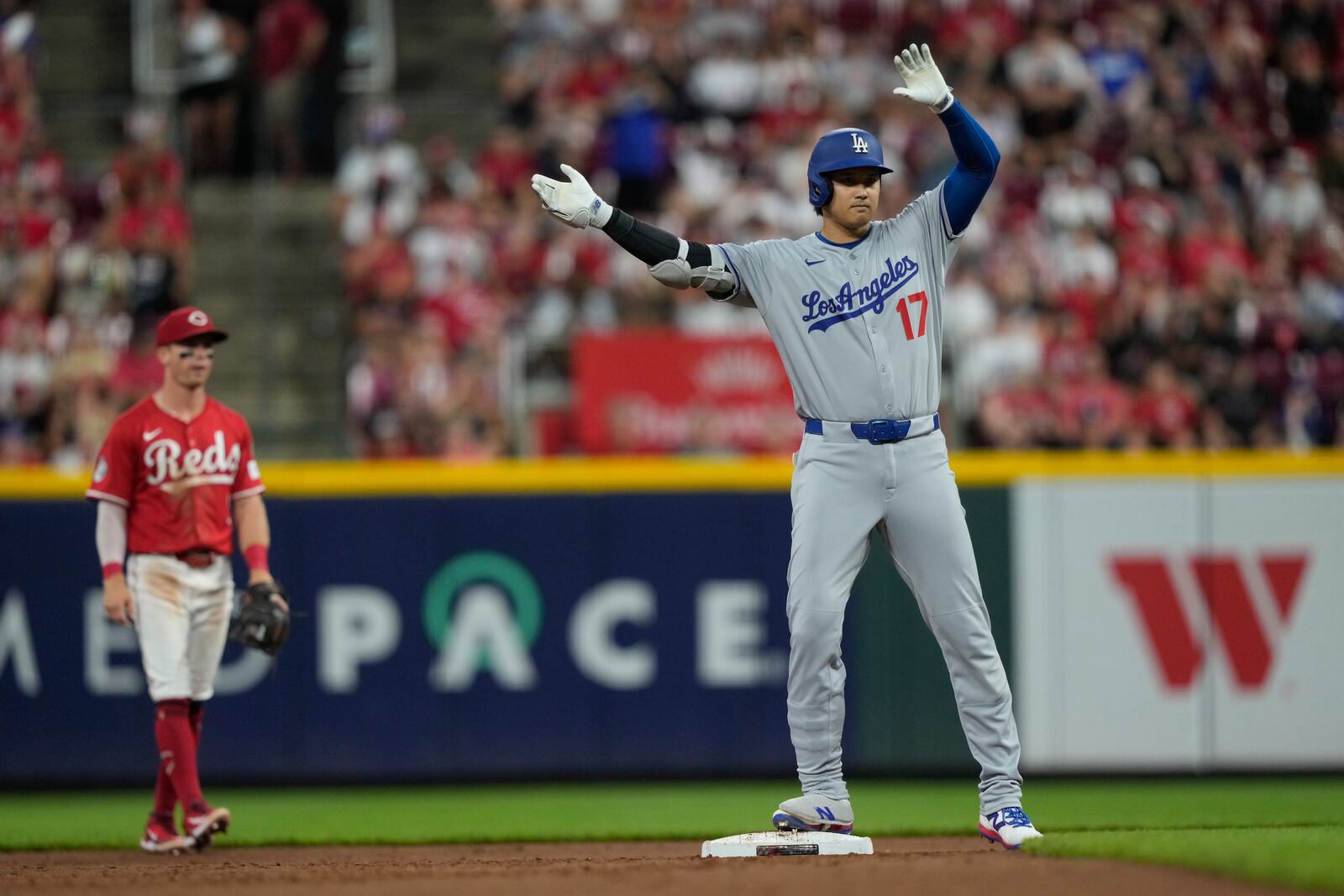 Los Angeles Dodgers' Shohei Ohtani celebrates on second base after hitting a double to score Miguel Rojas and Mookie Betts during the fifth inning of a baseball game against the Cincinnati Reds, Monday, July 28, 2025, in Cincinnati. (AP Photo/Carolyn Kaster)