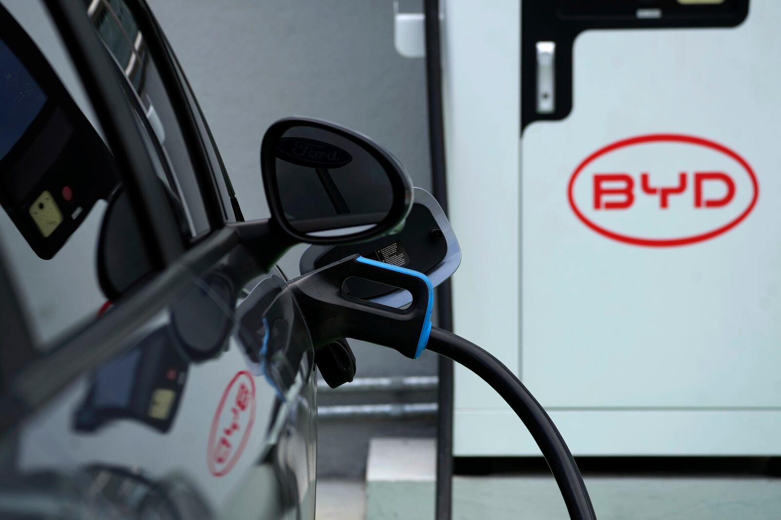 A BYD electric vehicle charges at a dealership in Camacari, Bahia state, Brazil, Friday, March 7, 2025. (AP Photo/Eraldo Peres)