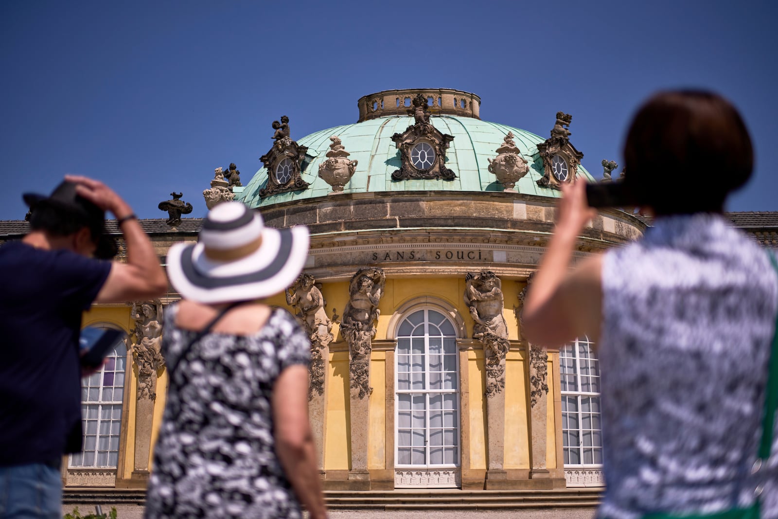 Visitors takes photos of Sanssouci Palace, the summer home of King Frederick II of Prussia, in Potsdam, Germany, June 17, 2025. (AP Photo/Markus Schreiber)