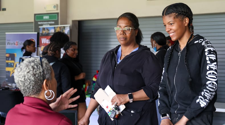 Shayann Turnbow (right) and her mother Stacy Hinton (middle) listen to a representative from YMCA of Greater Dayton (left) during a Montgomery County Youth Job Fair on May 2 at Day Air Ballpark. Turnbow is 15 years old, and Hinton said while her daughter isn’t necessarily looking for employment at the moment, she is getting a sense of job and volunteer opportunities that exist.