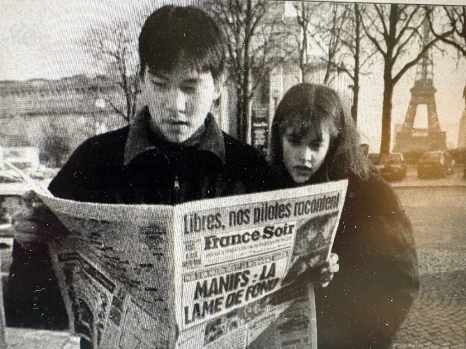 John Kim and Julie Waszczak read paper on Paris street. Headline describes the release of two French pilots by Bosnian Serbs. CONTRIBUTED