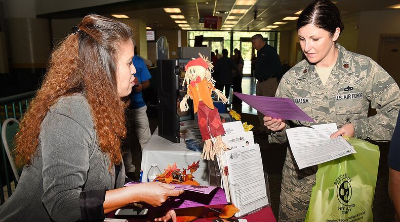 Maj. Allison Barkalow, Air Force Materiel Command deputy branch chief, views information displayed at a charity table during the Miami Valley Combined Federal Campaign kick-off event at Wright State University’s Nutter Center, Oct. 11. CFC provides an opportunity to learn about the work charitable organizations do locally, statewide, regionally, nationally and internationally. (U.S. Air Force photo/Michelle Gigante)