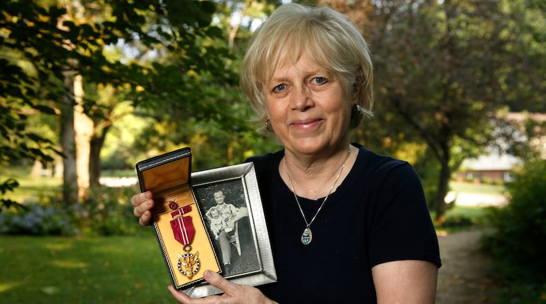 Deborah Anderson with her father, Joseph Desch's. Presidential Medal of Merit that President Truman awarded him in 1947 for his work on the bombe code-breaking machine. TY GREENLEES / STAFF