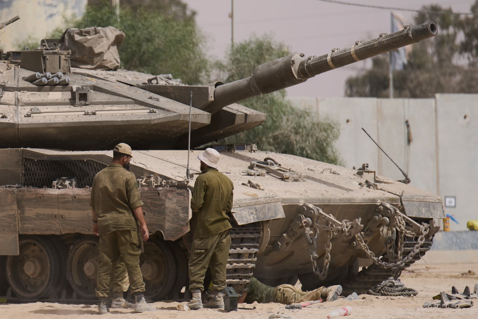 Israeli soldiers work on a tank at a staging area near the border with the Gaza Strip, in southern Israel, Tuesday, July 1, 2025. (AP Photo/Ariel Schalit)