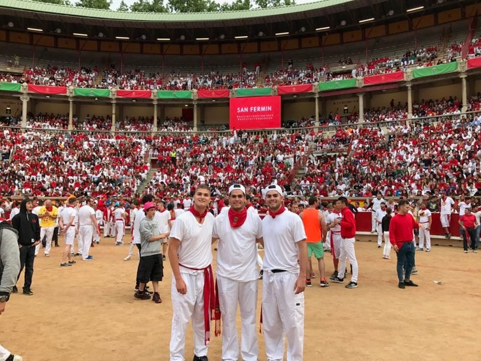 Dayton Flyers football player Christopher Papalia (right) with his twin brother Joseph (on left) and older brother Dominic (center) at the Running of the Bulls during the Festival of San Fermin in Pamplona, Spain. CONTRIBUTED