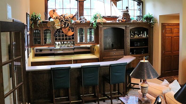 Woodmode solid cherry cabinets in the kitchen are complemented by granite counters. A raised granite counter wraps around two sides of the center island.
