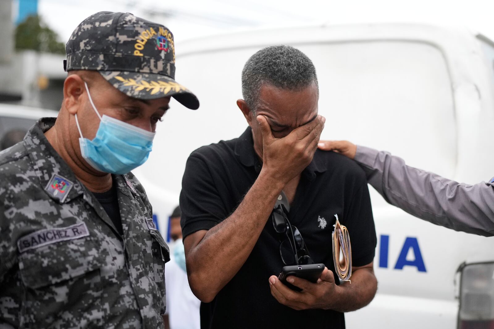 Carlos Severino, whose three children died in the Jet Set nightclub when a roof collapsed during a merengue concert, is consoled as he waits to receive the remains of his children, outside the morgue of the National Institute of Forensic Pathology in Santo Domingo, Dominican Republic, Friday, April 11, 2025. (AP Photo/Matias Delacroix)
