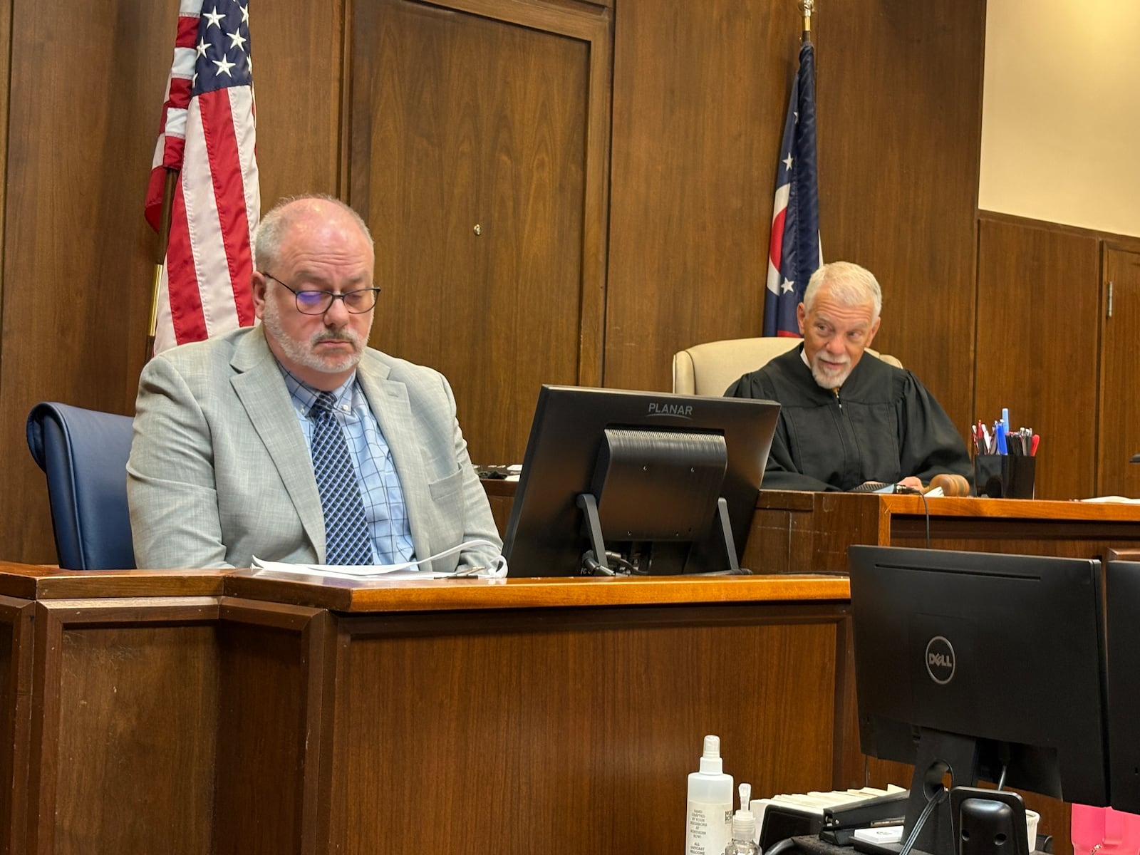 Miami Twp. Finance Director Clay McCord looks down at an exhibit Monday, March 9, 2026, in Montgomery County Common Pleas Court. At right is visiting Judge Jonathan Hein. JEN BALDUF/STAFF