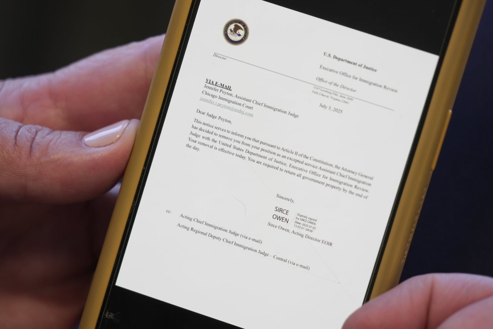 Jennifer Peyton shows the termination email for her former position as Assistant Chief Immigration Judge with the Department of Justice during an interview in Chicago on July 21, 2025. (AP Photo/Laura Bargfeld)