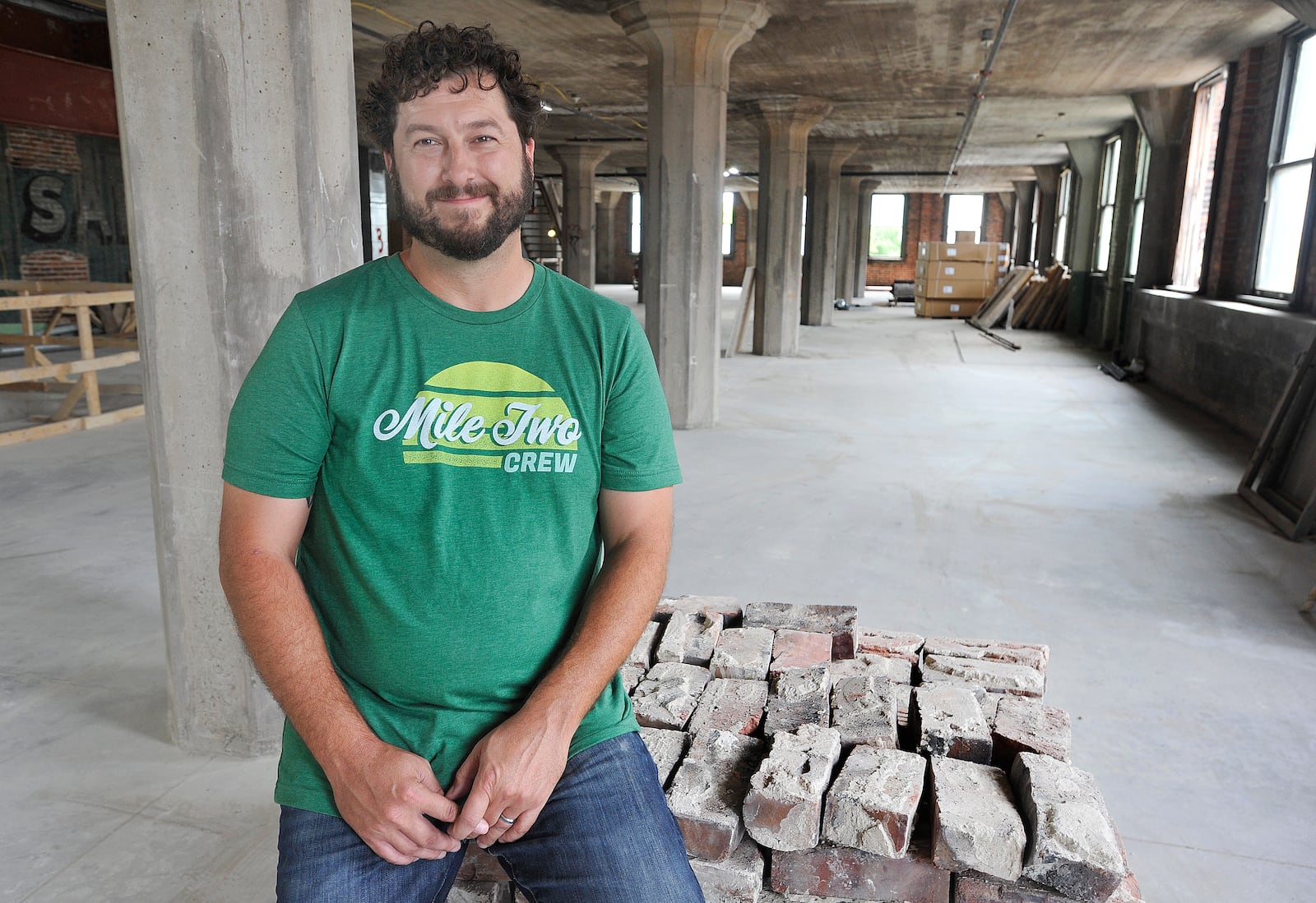 Jeff Graley, founder and CEO, of the Dayton software firm Mile Two, poses for a photo in his companies new location at the Manhattan on Third Street. MARSHALL GORBY\STAFF