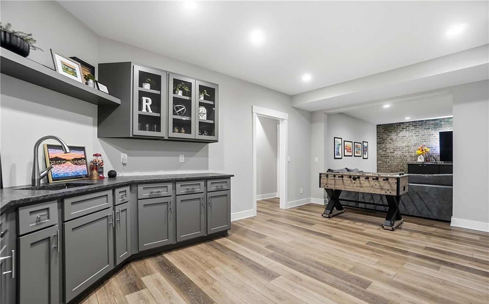 The finished basement has two bedrooms and one and half baths and a recreation room with a kitchenette and brick accent wall. CONTRIBUTED