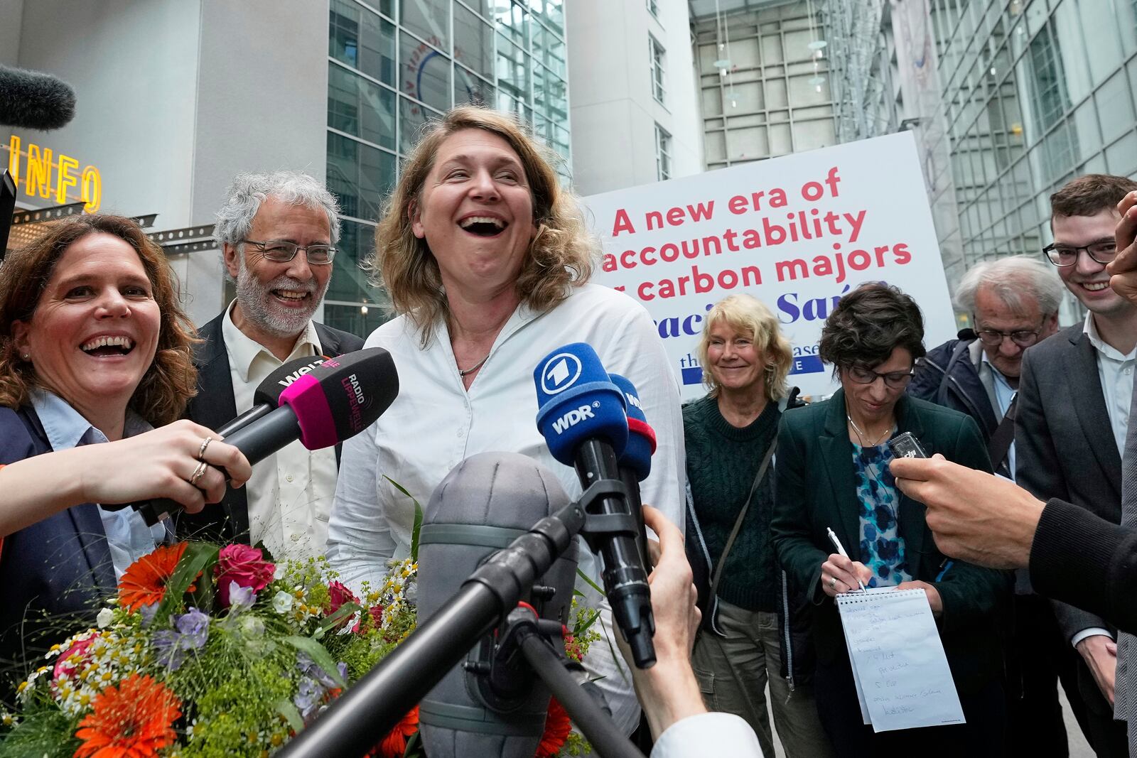 Plaintiff's attorney Roda Verheyen celebrates with her team after the verdict in the climate damages case of plaintiff Peruvian farmer Luciano Lliuya against the German energy company RWE for its carbon emissions, at the Higher Regional Court in Hamm, Germany, Wednesday, May 28, 2025. (AP Photo/Martin Meissner)