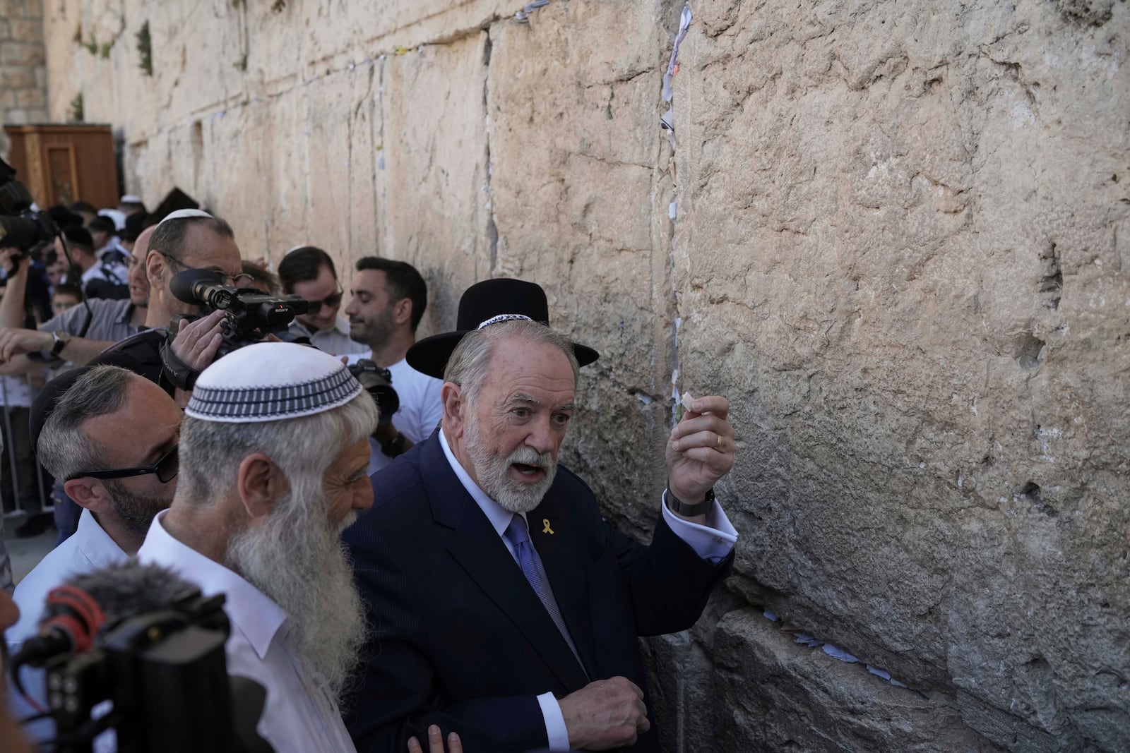 The US ambassador to Israel Mike Huckabee holds a note given to him from US President Donald Trump to be placed in the cracks of the Western Wall, the holiest site where Jews can pray, in the Old City of Jerusalem, Friday, April 18, 2025. (AP Photo/Leo Correa)