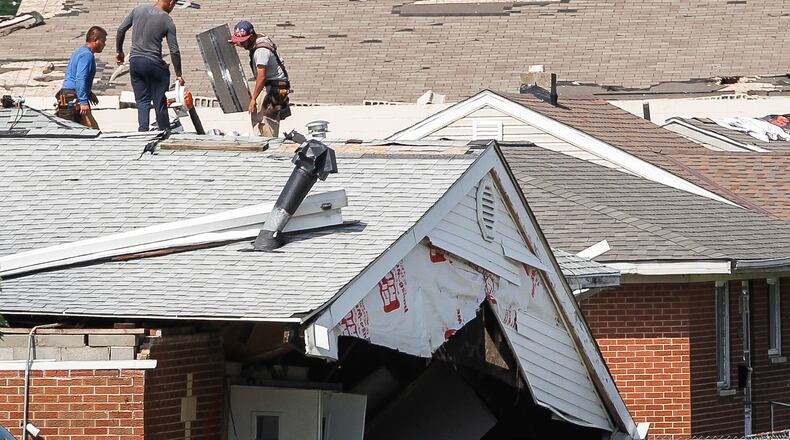 Workers repair the roof of a house in Harrison Twp. next to the Union Chapel Community Church that was destroyed by a Memorial Day tornado. CHRIS STEWART / STAFF