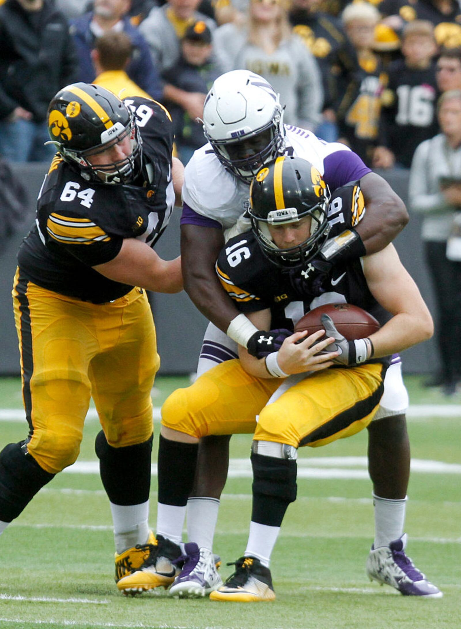 IOWA CITY, IOWA- OCTOBER 1: Quarterback C.J. Beathard #16 of the Iowa Hawkeyes is sacked during the third quarter by defensive lineman Ifeadi Odenigbo #7 of the Northwestern Wildcats on October 1, 2016 at Kinnick Stadium in Iowa City, Iowa. (Photo by Matthew Holst/Getty Images)