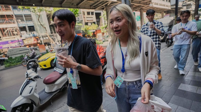 Porwares Tantikanpanit, left, drinks coffee in Bangkok, Thailand, Wednesday, Feb. 11, 2026. (AP Photo/Sakchai Lalit)