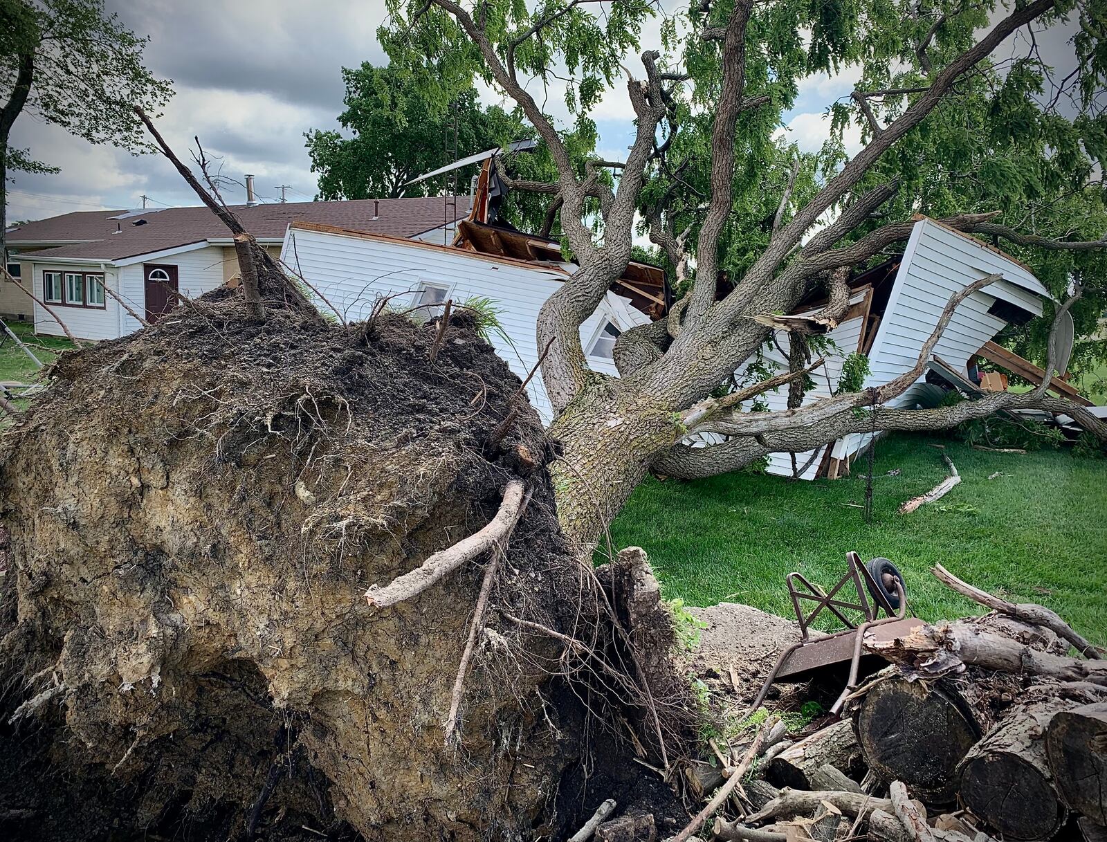 An uprooted tree destroyed a garage on Peters Road in Troy during storms Wednesday, June 8, 2022. Cleanup was underway in the area Thursday following the storms, which included tornadoes near Tipp City and north of Springfield. MARSHALL GORBY/STAFF