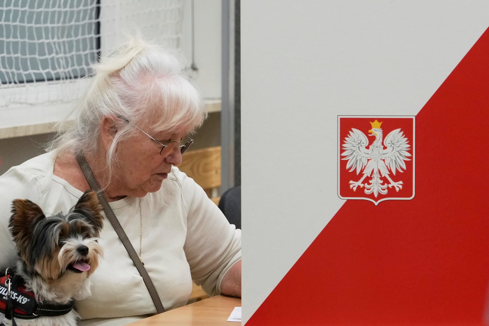 A women prepares to cast her vote during the presidential election runoff in Warsaw, Poland, Sunday, June 1, 2025. (AP Photo/Czarek Sokolowski)
