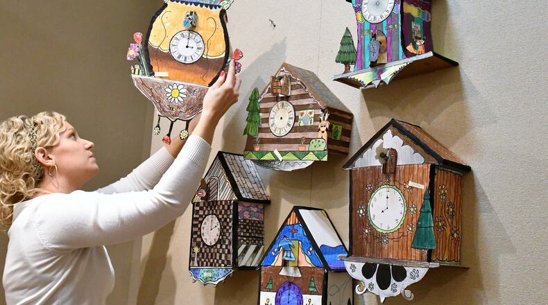 Sara Schmitmeyer, art teacher at St. Patrick school, Troy, hangs works by her fifth-grade students in the annual Young Masters art exhibit at the Troy Hayner Cultural Center. CONTRIBUTED