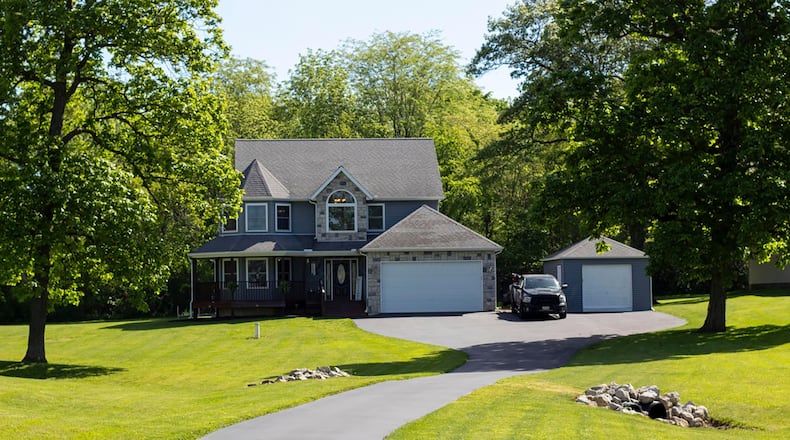 This stone and vinyl two story sits back on a wooded lot. It has a two car attached and one car detached garage and wrap around porch.