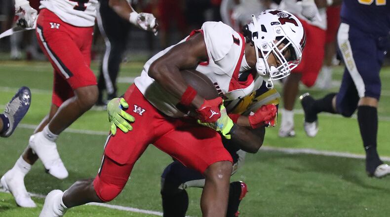 Wayne's Rj Mukes is tackled by a Springfield player during Friday's game. BILL LACKEY/STAFF