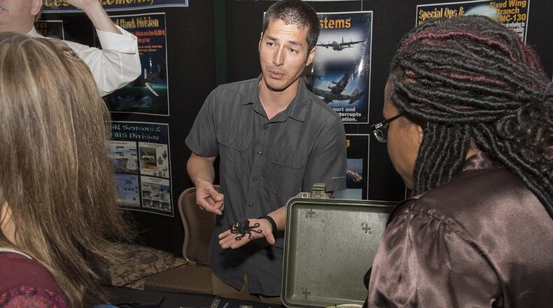 Chris Buck (center), Rapid Development Integration Facility program manager, shows a test article example to visitors during the Air Force Life Cycle Management Center’s Newcomers Expo at Wright-Patterson Air Force Base Sept. 22. RDIF build and deliver weapon system modifications for items that do not exist currently on a weapon system, are too expensive or are no longer produced. (U.S. Air Force photo/Michelle Gigante)