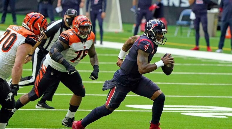 Houston Texans quarterback Deshaun Watson (4) rushes for a gain as Cincinnati Bengals' Margus Hunt (70) and Mike Daniels (76) defend during the second half of an NFL football game Sunday, Dec. 27, 2020, in Houston. (AP Photo/Eric Christian Smith)