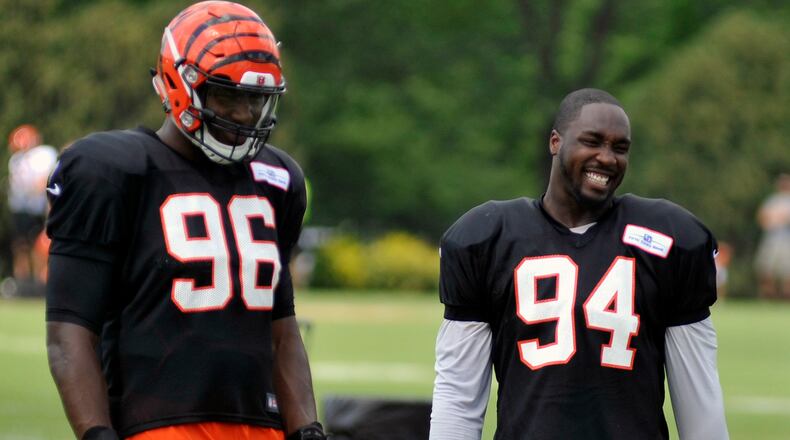 Cincinnati Bengals defensive ends Chris Smith (right) and Carlos Dunlap share a laugh during a break in Thursday’s practice at Paul Brown Stadium. JAY MORRISON/STAFF