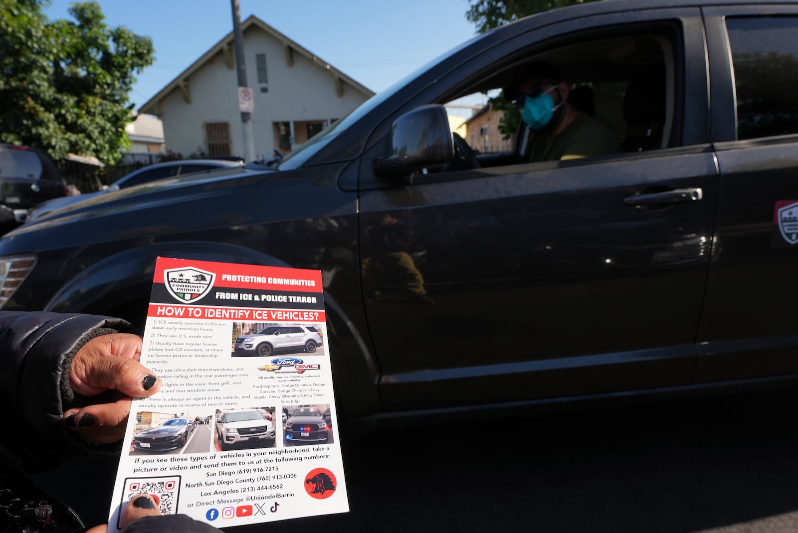A member of the Union del Barrio, a grassroots political organization, distributes a "How to Identify ICE vehicles" flyer to people living in Los Angeles, Monday, June 16, 2025. (AP Photo/Damian Dovarganes)
