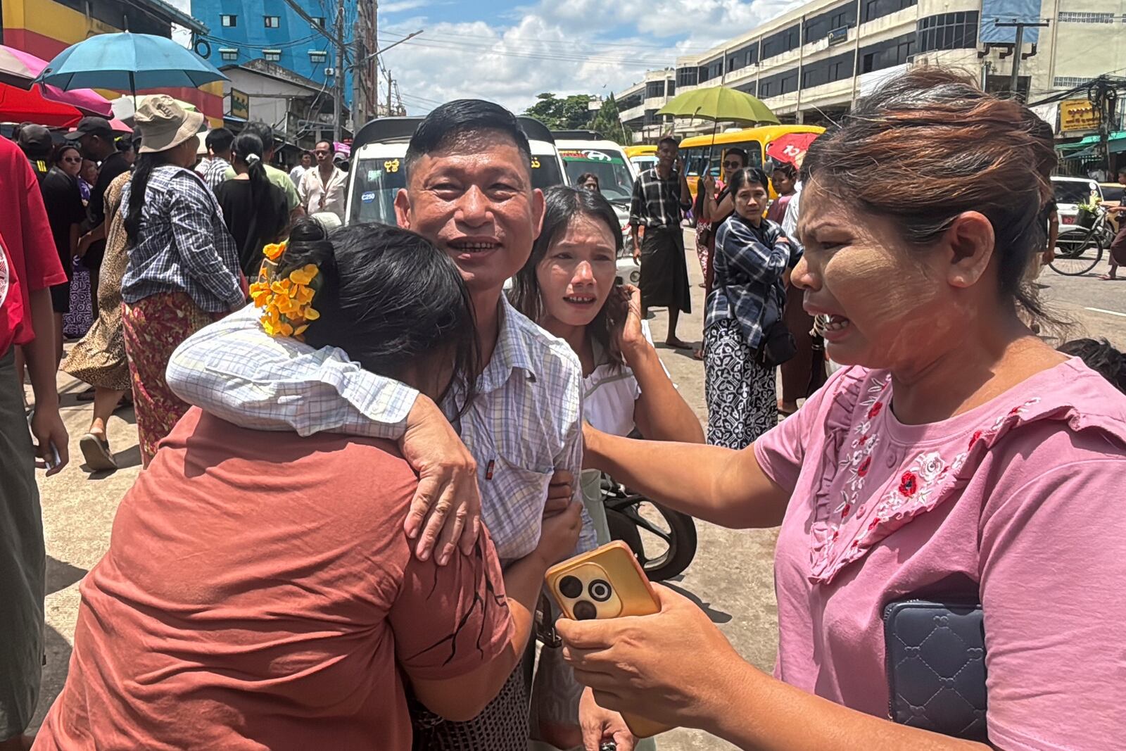 A released prisoner, center, is welcomed by family members outside the main gate of Insein prison as the head of Myanmar’s military government granted amnesty to thousands of prisoners to mark the country's traditional New Year Thursday, April 17, 2025, in Yangon, Myanmar. (AP Photo/Thein Zaw)