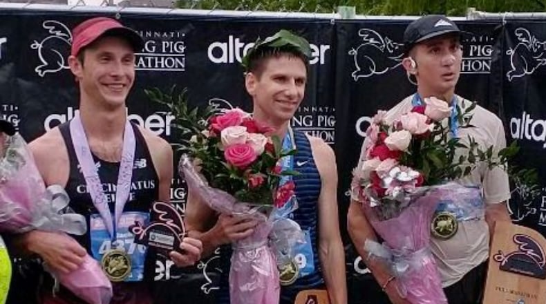 Jason Salyer, center, poses for a photo after winning the Flying Pig Marathon on Sunday, May 7, 2023, in Cincinnati. Salyer won his second straight Flying Pig Marathon on Sunday in Cincinnati. Photo by Jim Salyer