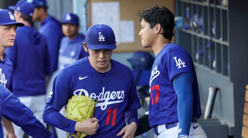 Los Angeles Dodgers starting pitcher Roki Sasaki (11) is greeted by designated hitter Shohei Ohtani, right, after being taken off the mound during the first inning of a spring training baseball game against the Los Angeles Angels, Monday, March 23, 2026, in Los Angeles. (AP Photo/Ryan Sun)