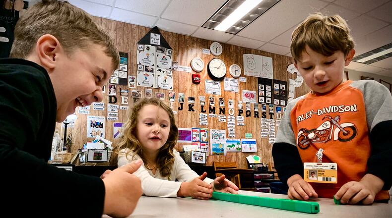 First-grade students (left to right) Parker Richey, Remi Kinney, and Declan Cogan work on counting skills in Sarah Jacobs' math class at Primary Village North school in Centerville in this 2024 photo.  Centerville is nearly two years ahead in math scores using a new curriculum they rolled out two years ago. MARSHALL GORBY\STAFF