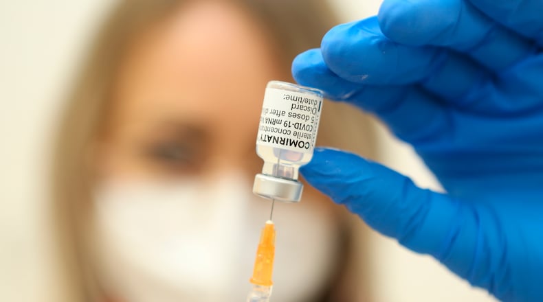 Emergency paramedic Mandy Fleck draws up a syringe of Corona vaccine from Biontech/Pfizer in Emsleben, Germany, Thursday, March 10, 2021. (Matthias Bein/dpa via AP)