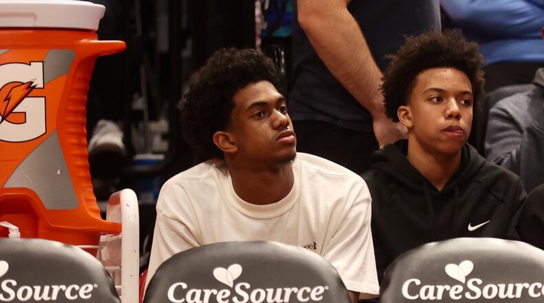 Dayton recruit Jaron McKie, center, sits behind the UD bench during a game against Northwestern on Saturday, Nov. 9, 2024, at UD Arena. David Jablonski/Staff