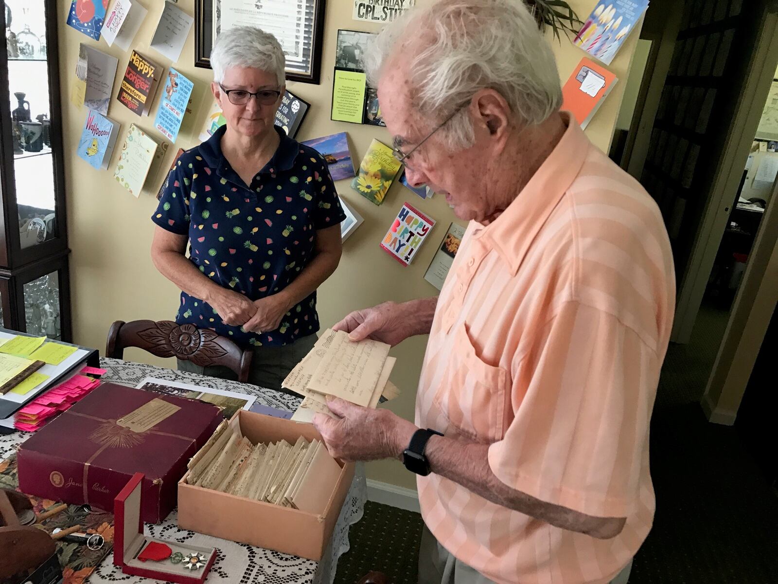With daughter Beverly Rutan looking on, Walter Stitt looks at one of the 82 letters (the rest are in the hat box in front of him) he wrote during World War II to his mother who was living in West Virginia. Some of his letters were penned when he was in basic and advanced training at Camp Polk, Louisiana and the rest came as he served in Sherman tanks in France, Belgium and Germany. He was in some of the war’s deadliest battles: the Battle of Normandy and the Battle of the Bulge. Twice his tank commanders and others alongside him in tanks were killed by German shells. He received two Purple Hearts; the National Order of the Legion of Merit, the highest honor of France; and the Order of Saint George Medallion, the top award given to members of the Army's mounted force (tanks, cavalry) by the United States Armor Association of the United States Army. Tom Archdeacon photo