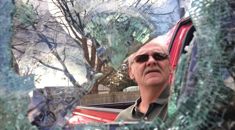 William Domer, of South Belmont Avenue, looks at the window shattered by a thief who broke into the truck that was sitting in his driveway. (Allison Wichie/Staff)
