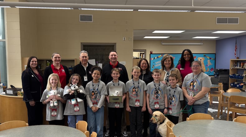 Members of the National Association of Federally Impacted Schools visited Beverly Gardens Elementary School to learn more about the Mad River Local School District’s support for military-connected students.
Pictured, back row, from left are Andrea Edmonds, WPAFB School Liaison; Anne O'Brien, NAFIS Communications Director; Jerry Ellender, MRLS Treasurer; Chad Wyen, MRLS Superintendent; Cherise Imai, NAFIS Executive Director; Cristi Fields, Beverly Gardens Principal; Shatila Smith, WPAFB School Liaison. Front row, Beverly Gardens Anchored4Life members; Otto, school facility dog. During the visit, NAFIS Executive Director Cherise Imai and Communications Director Anne O’Brien met with members of the Anchored4Life team, a peer-to-peer resiliency program designed to support students experiencing transitions. MAD RIVER SCHOOLS/CONTRIBUTED