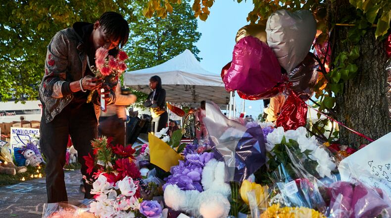 A man lays flowers on Tuesday, May 17, 2022, at a makeshift memorial to the victims of the racist mass shooting in Buffalo, N.Y. The accused gunman in Saturday’s massacre at a supermarket in Buffalo appeared in court on Thursday morning, May 19, 2022, facing a count of murder in the first degree, as some family members of the 10 people he is accused of killing looked on. (Mustafa Hussain/The New York Times)