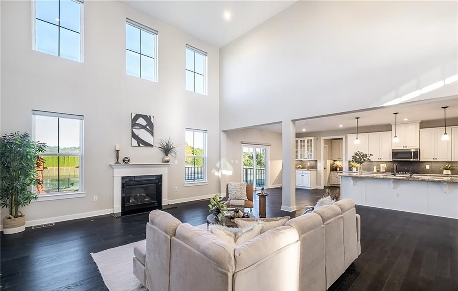 The open concept great room and kitchen has hardwood floors throughout. The two story great room has a fireplace and wall of windows and the kitchen has an island with bar seating and a breakfast nook. CONTRIBUTED