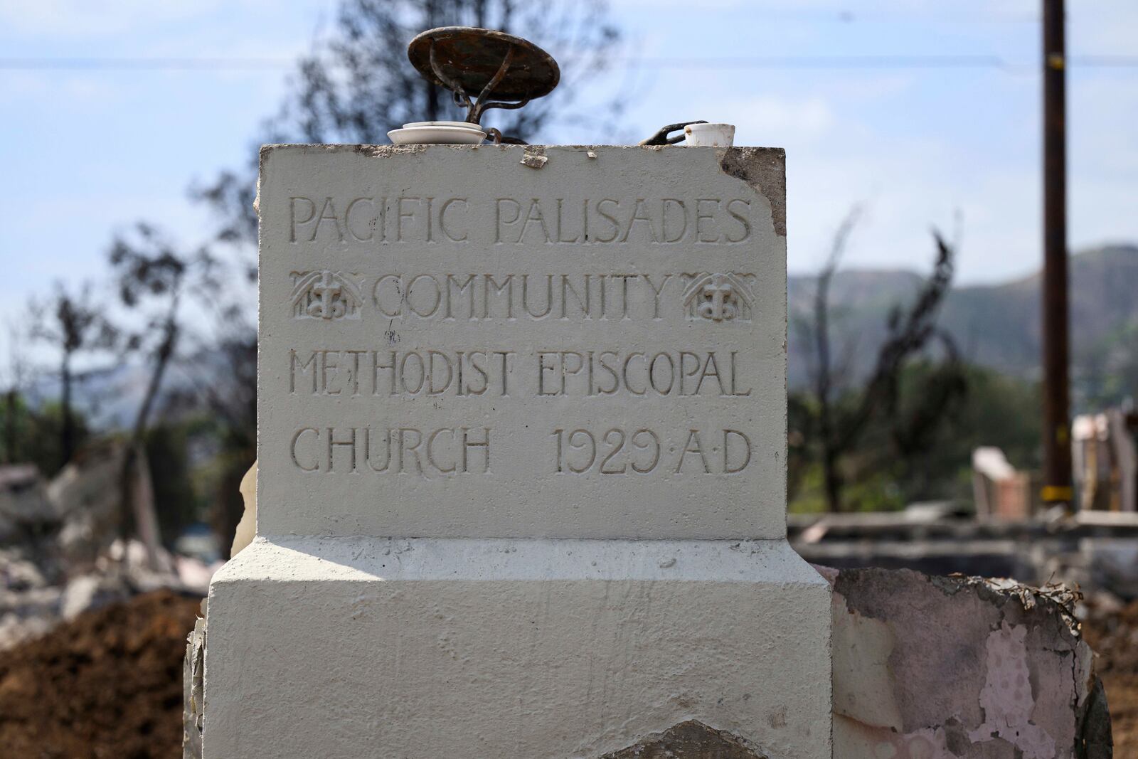 The remains of the cornerstone of the Community United Methodist Church of the Pacific Palisades are shown, Friday, April 18, 2025, in the Pacific Palisades area of Los Angeles. (AP Photo/William Liang)
