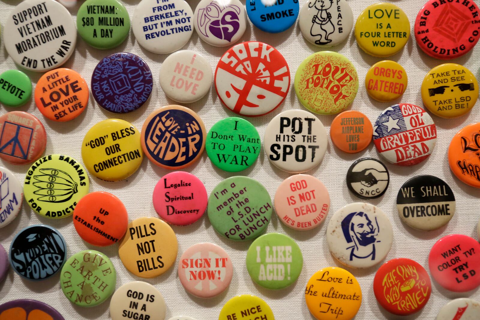 This Wednesday, May 10, 2017 photo shows a display of buttons in the exhibit "The Summer of Love Experience, Art, Fashion and Rock and Roll" in Golden Gate Park at the deYoung Museum in San Francisco. (AP Photo/Eric Risberg)