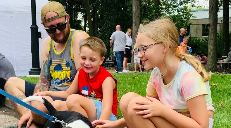 Hudson and Harper Waitukaitis are greeted by a very friendly beagle at the 2022 Holiday at Home festival. LONDON BISHOP/STAFF