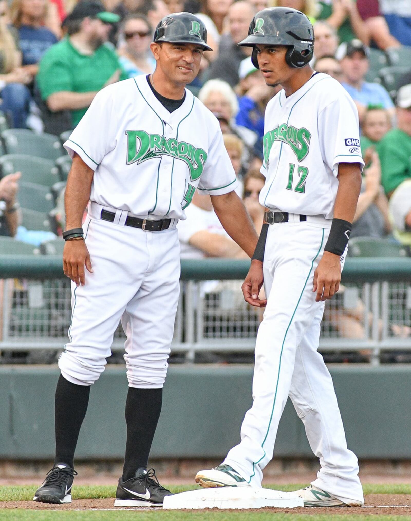 Dragons manager Luis Bolivar congratulates center fielder Jose Siri during a Midwest League game against Lansing on Monday, Aug. 7, 2017, at Fifth Third Field. Contributed Photo by Bryant Billing