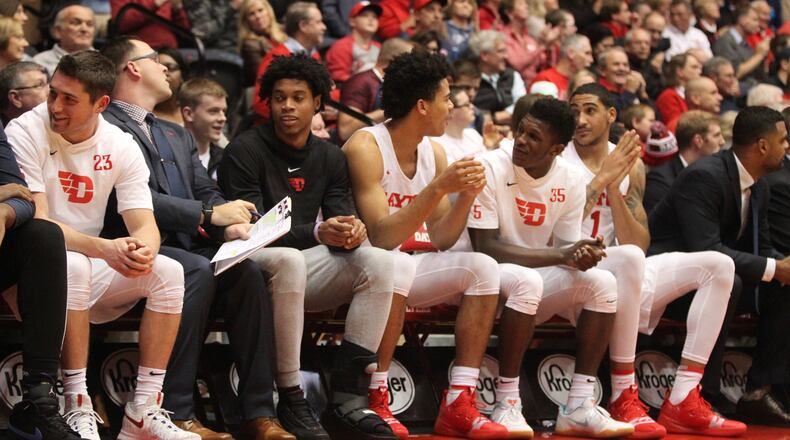 Dayton’s Jhery Matos, third from left, sits on the bench in a protective boot during a game against Mississippi State on Friday, Nov. 30, 2018, at UD Arena.