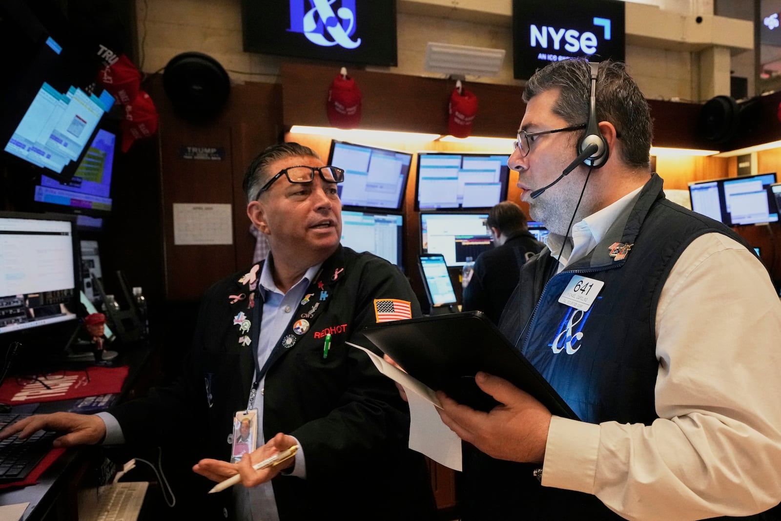 Traders Jonathan Muller, left, and Michael Capolino work on the floor of the New York Stock Exchange, Friday, April 4, 2025. (AP Photo/Richard Drew)