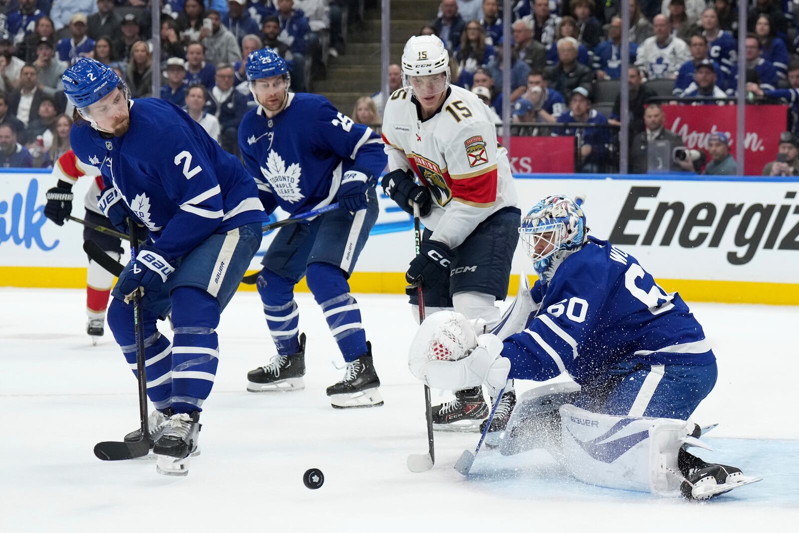 Toronto Maple Leafs goaltender Joseph Woll (60) makes a save while under pressure from Florida Panthers forward Anton Lundell (15) as Maple Leafs' Simon Benoit (2) and Brandon Carlo (25) watch during the third period of Game 1 in an NHL hockey second-round playoff series in Toronto, Monday, May 5, 2025. (Nathan Denette/The Canadian Press via AP)