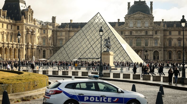 A police car parks in the courtyard of the Louvre museum, one week after the robbery, Sunday, Oct. 26, 2025 in Paris. The Paris prosecutor said on Sunday that a number of suspects have been arrested over the theft of crown jewels from Paris' Louvre museum last weekend. (AP Photo/Thomas Padilla)