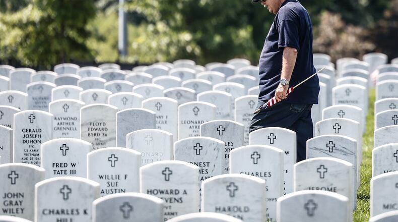 Fairborn resident and Retired Air Force master sergeant Henry Harlow delivers a flag to friend buried at the Dayton National Cemetery on West Third St. JIM NOELKER/STAFF