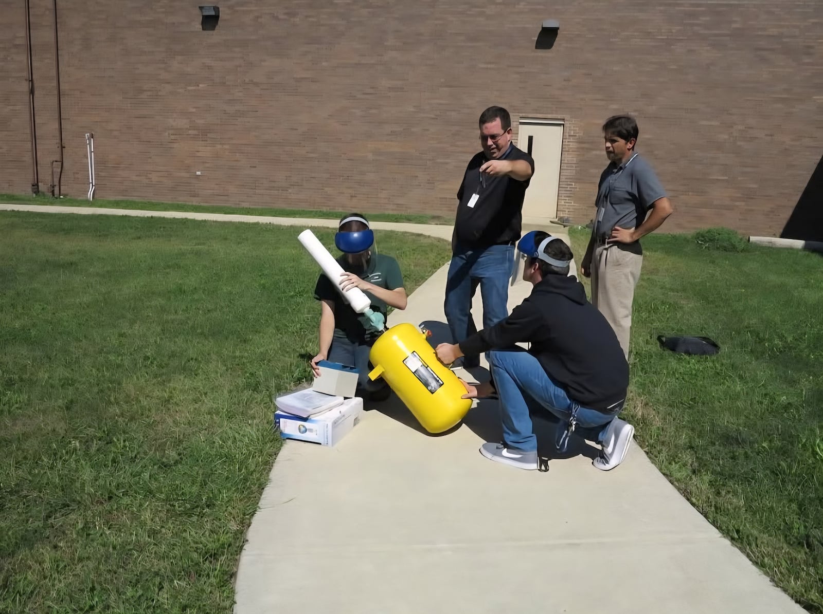 Spencer Kuritar (far right) and his classmates were juniors in 2017 when they constructed a pneumatic potato launcher from spare parts found at the school. They are shown testing it outside of the school. CONTRIBUTED